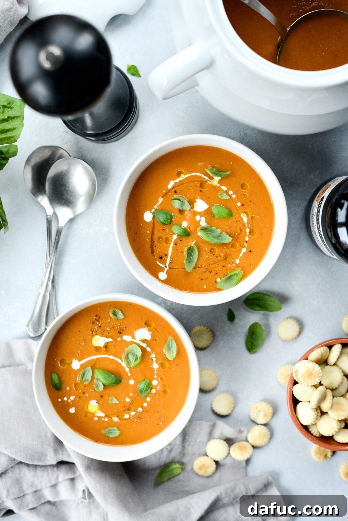 A beautifully presented bowl of Roasted Tomato Pumpkin Soup, garnished and ready for a cozy meal, with a spoon resting in it