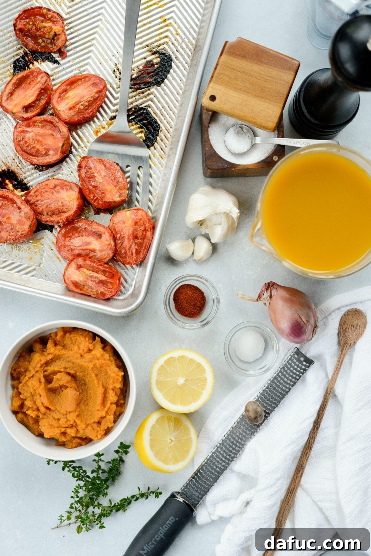 Fresh ingredients laid out for Roasted Tomato Pumpkin Soup, including Roma tomatoes, shallots, garlic, thyme, and canned pumpkin puree