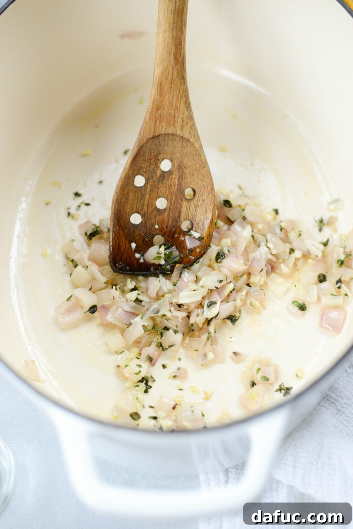Sautéed shallots and garlic with fresh thyme in a pan, releasing their fragrant aromas