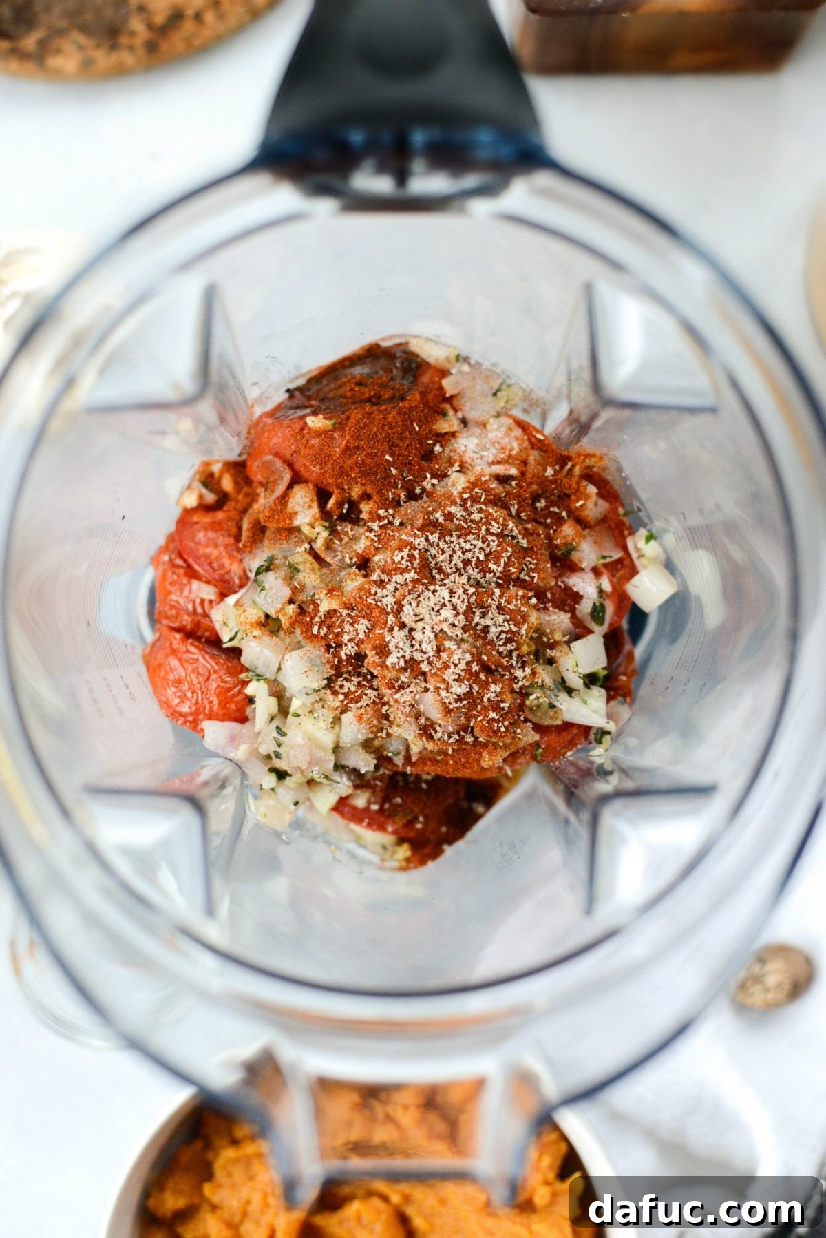 All ingredients including roasted tomatoes, shallot mixture, pumpkin puree, and spices added to the blender for pureeing