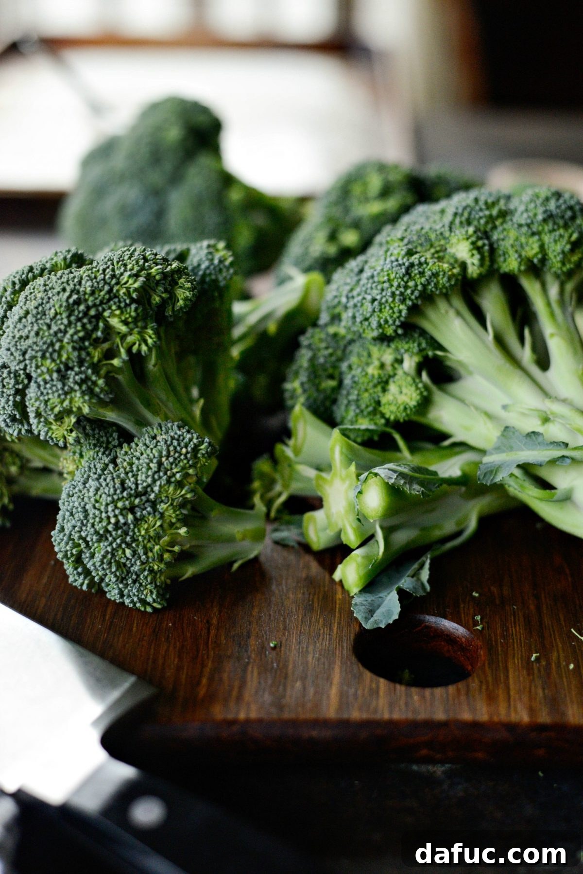 Broccoli florets ready to be roasted on a baking sheet.