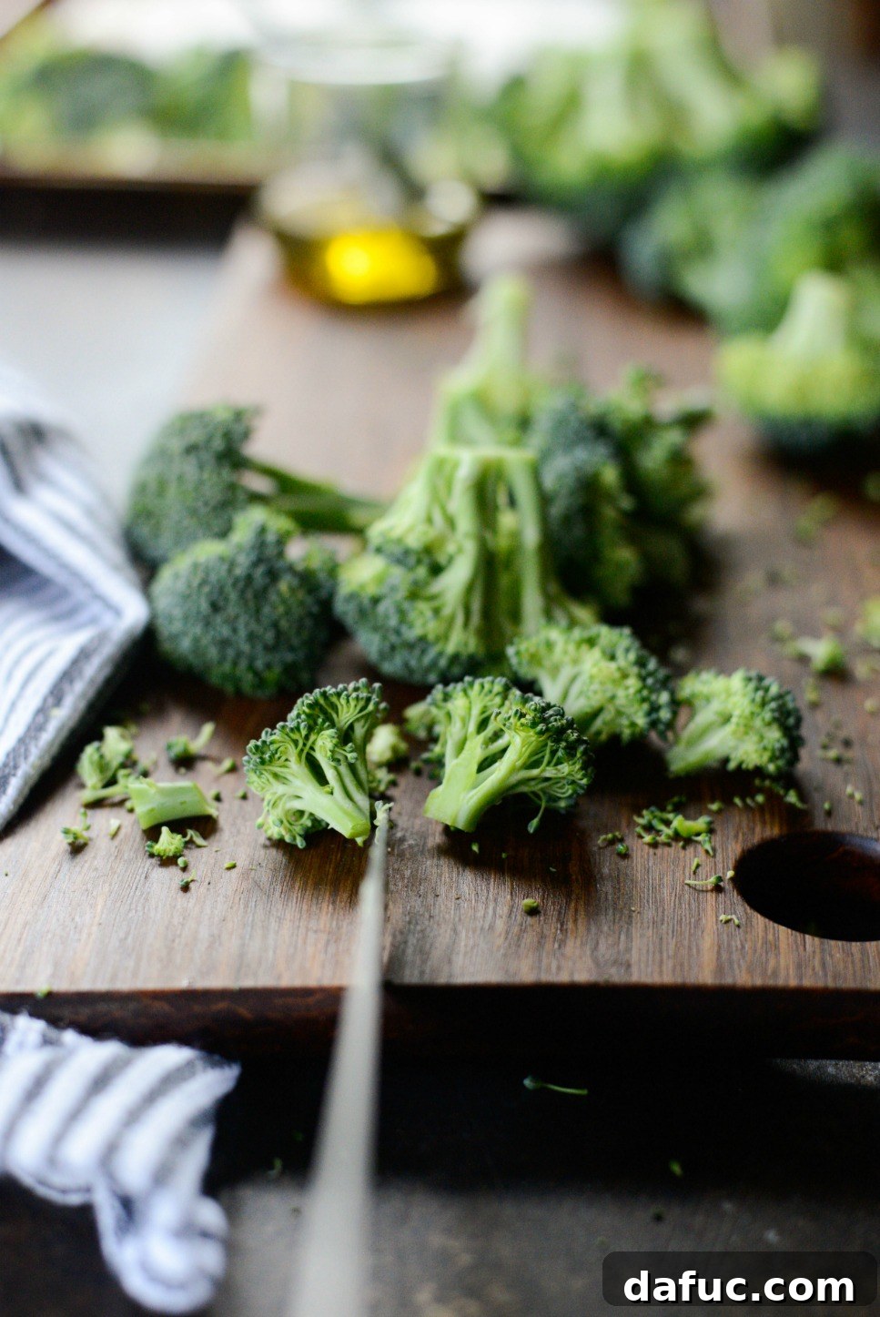 Bite-size broccoli florets spread on a baking sheet, ready for seasoning.