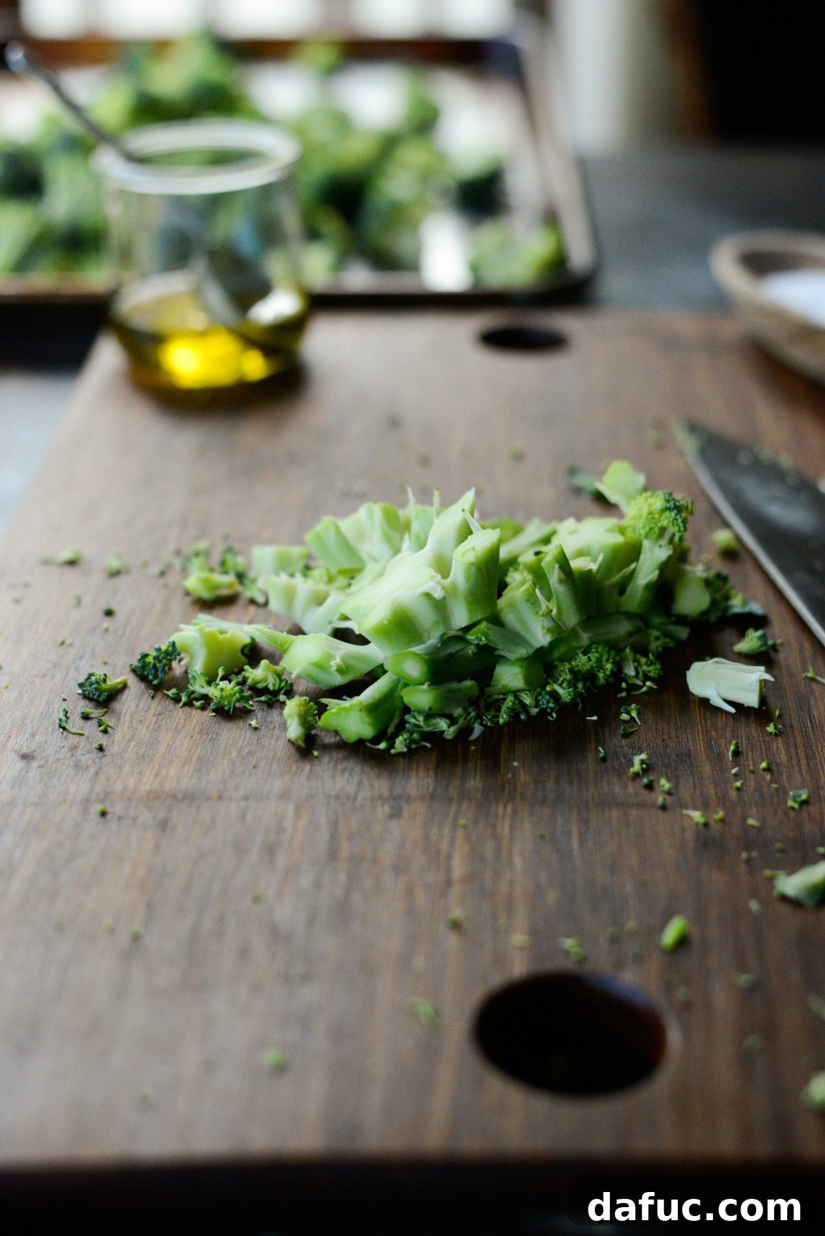 Broccoli scraps, including stems, on a cutting board, demonstrating that they shouldn't be discarded.
