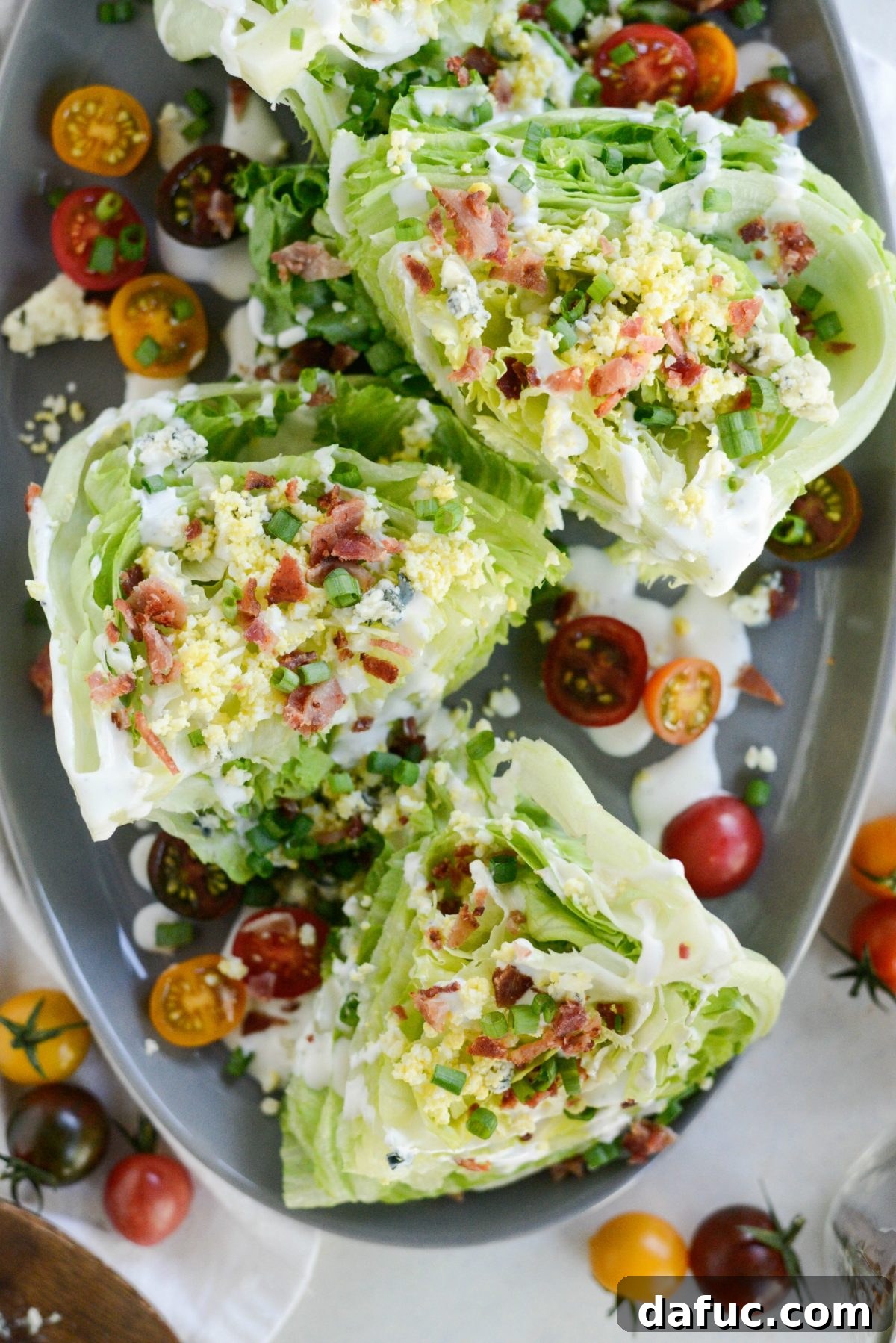 Our Signature Loaded Wedge, Drenched in Peppercorn Buttermilk 9 A beautifully assembled Loaded Wedge Salad with Black Pepper Buttermilk Dressing, showcasing all the toppings and the rich dressing cascading down the lettuce.