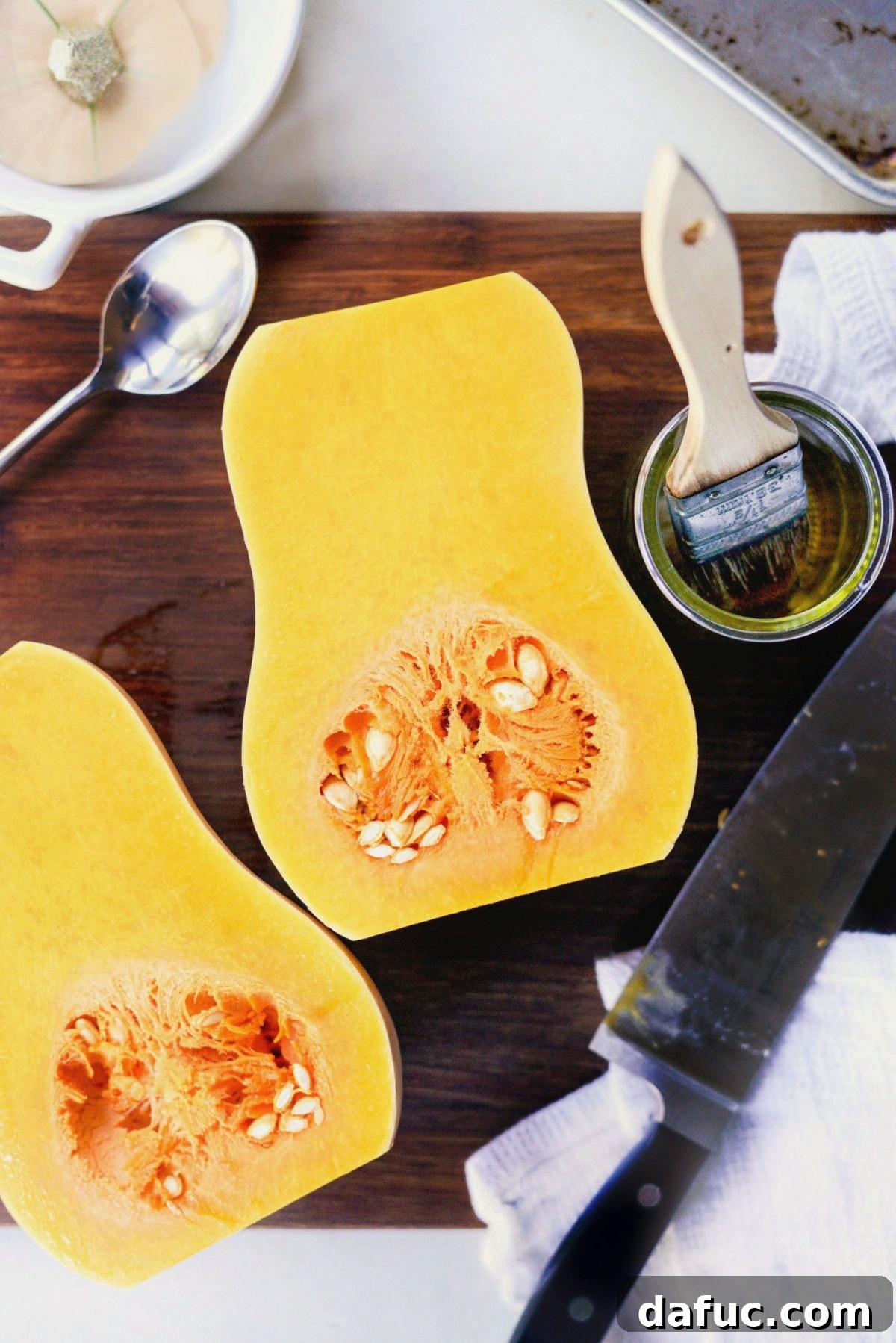 Butternut squash cut in half lengthwise, showing the seeds and flesh.
