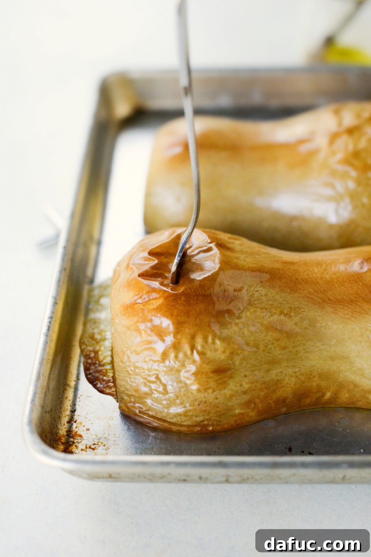 Roasted butternut squash halves, showing tender flesh and slightly browned edges.