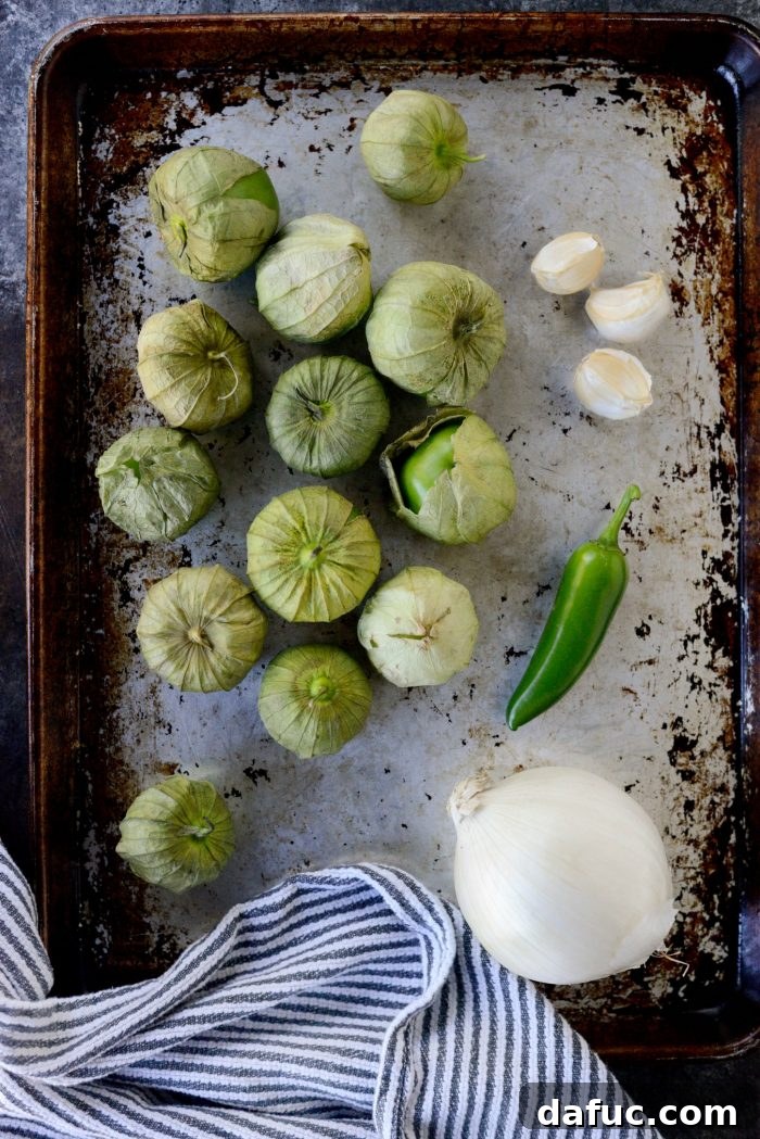 Effortless Zingy Tomatillo Salsa Verde 4 Fresh ingredients for Easy Salsa Verde laid out on a cutting board