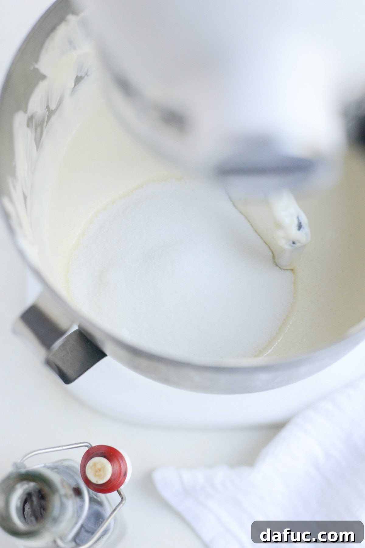 Tangy Goat Cheese Cheesecake with Tahini-Kissed Shortbread Base 12 Granulated sugar being added to the cheesecake batter in the stand mixer