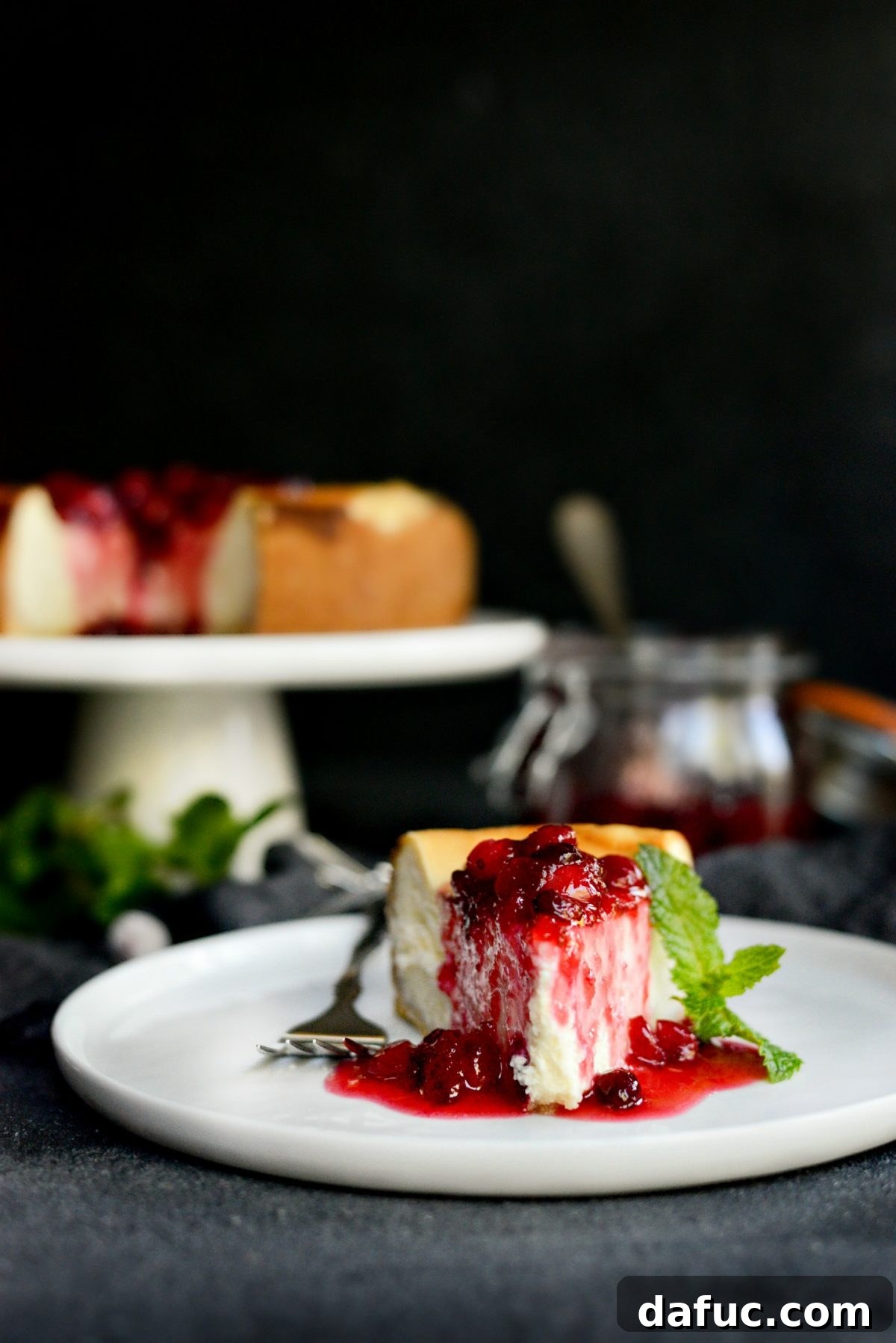 Tangy Goat Cheese Cheesecake with Tahini-Kissed Shortbread Base 19 A beautifully presented slice of Goat Cheese Cheesecake on a white plate, showcasing its layers and topping