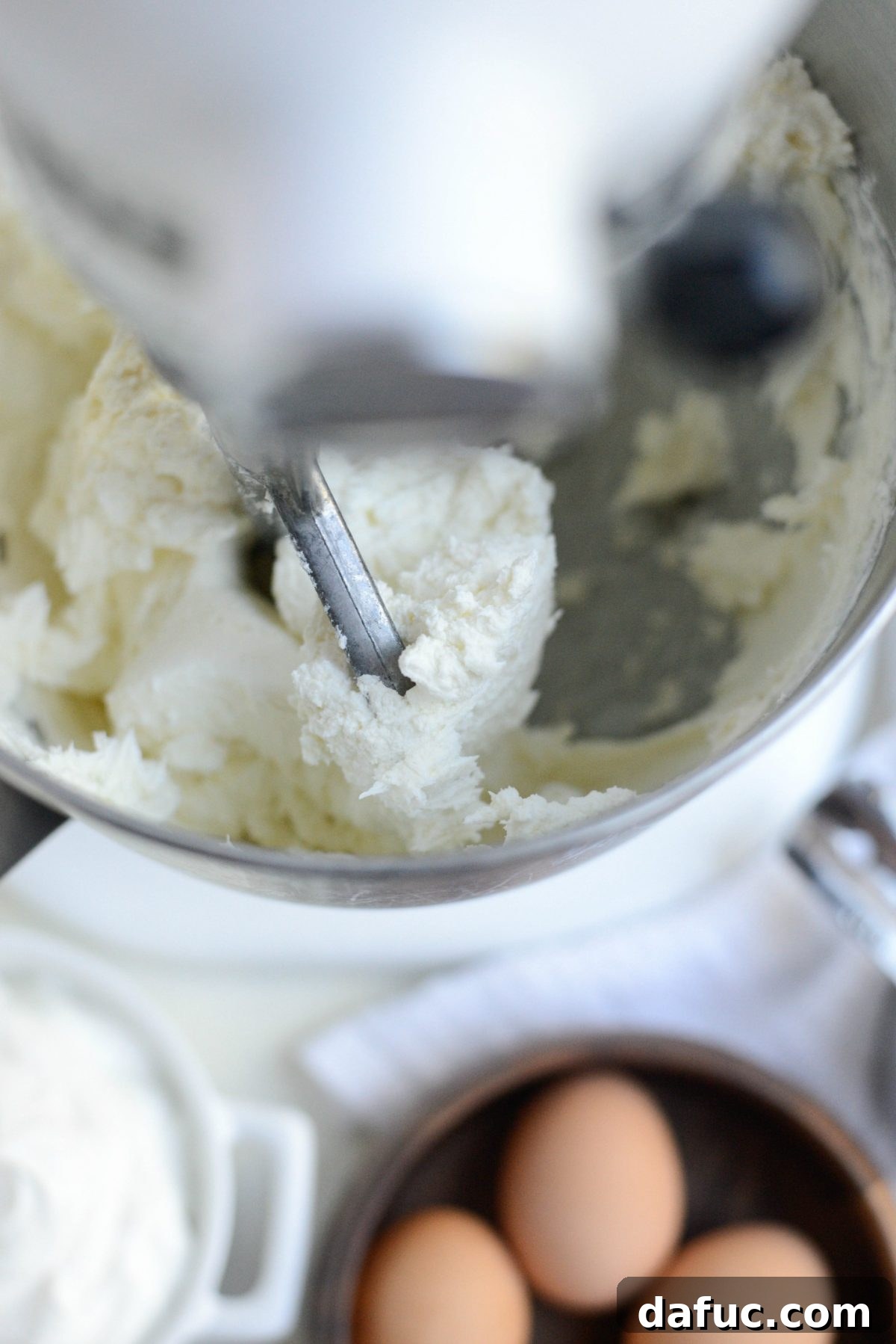 Tangy Goat Cheese Cheesecake with Tahini-Kissed Shortbread Base 9 Stand mixer blending cream cheese and goat cheese until the mixture is smooth and fully incorporated