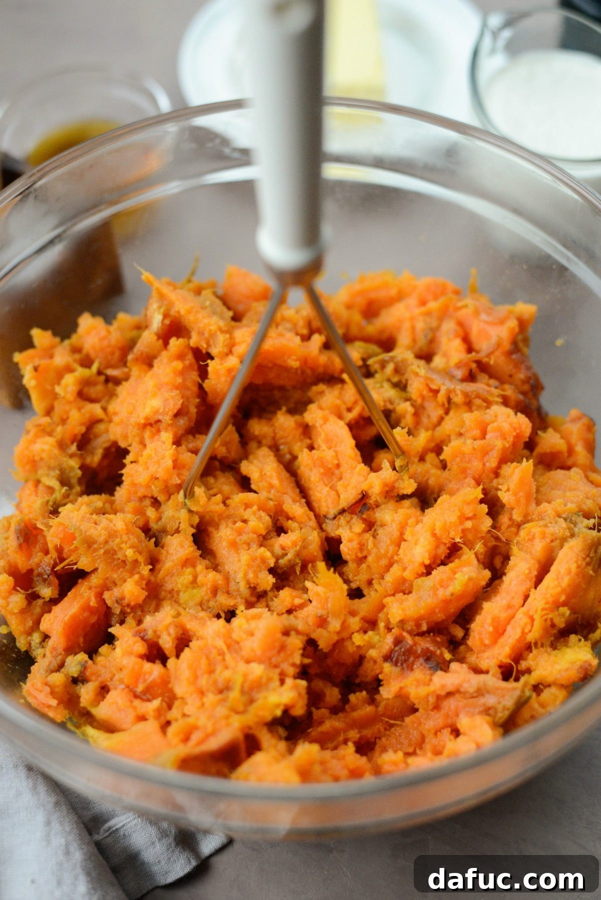 Silky Maple Sweet Potato Mash 7 Close-up of mashed sweet potatoes in a bowl, ready for butter and other ingredients