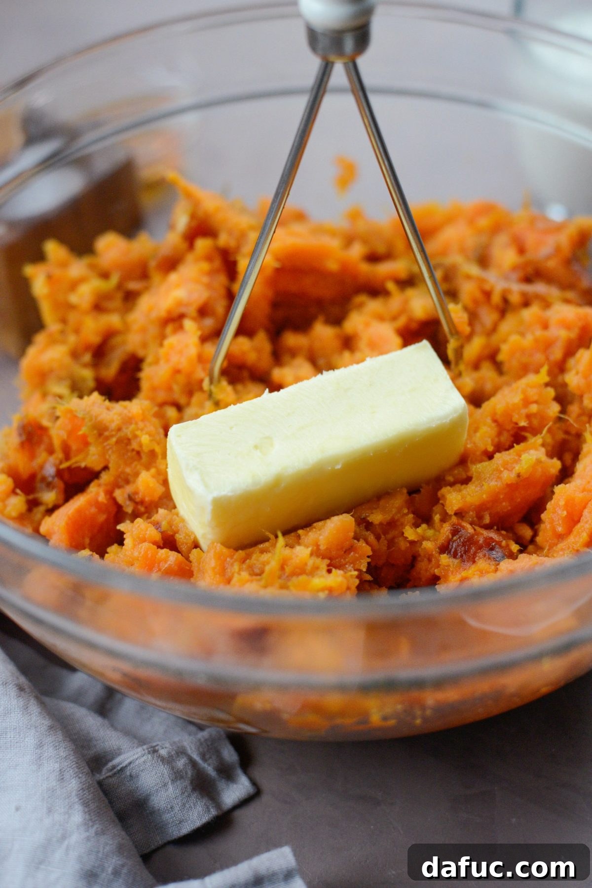 Silky Maple Sweet Potato Mash 8 Adding softened butter to the mashed sweet potatoes