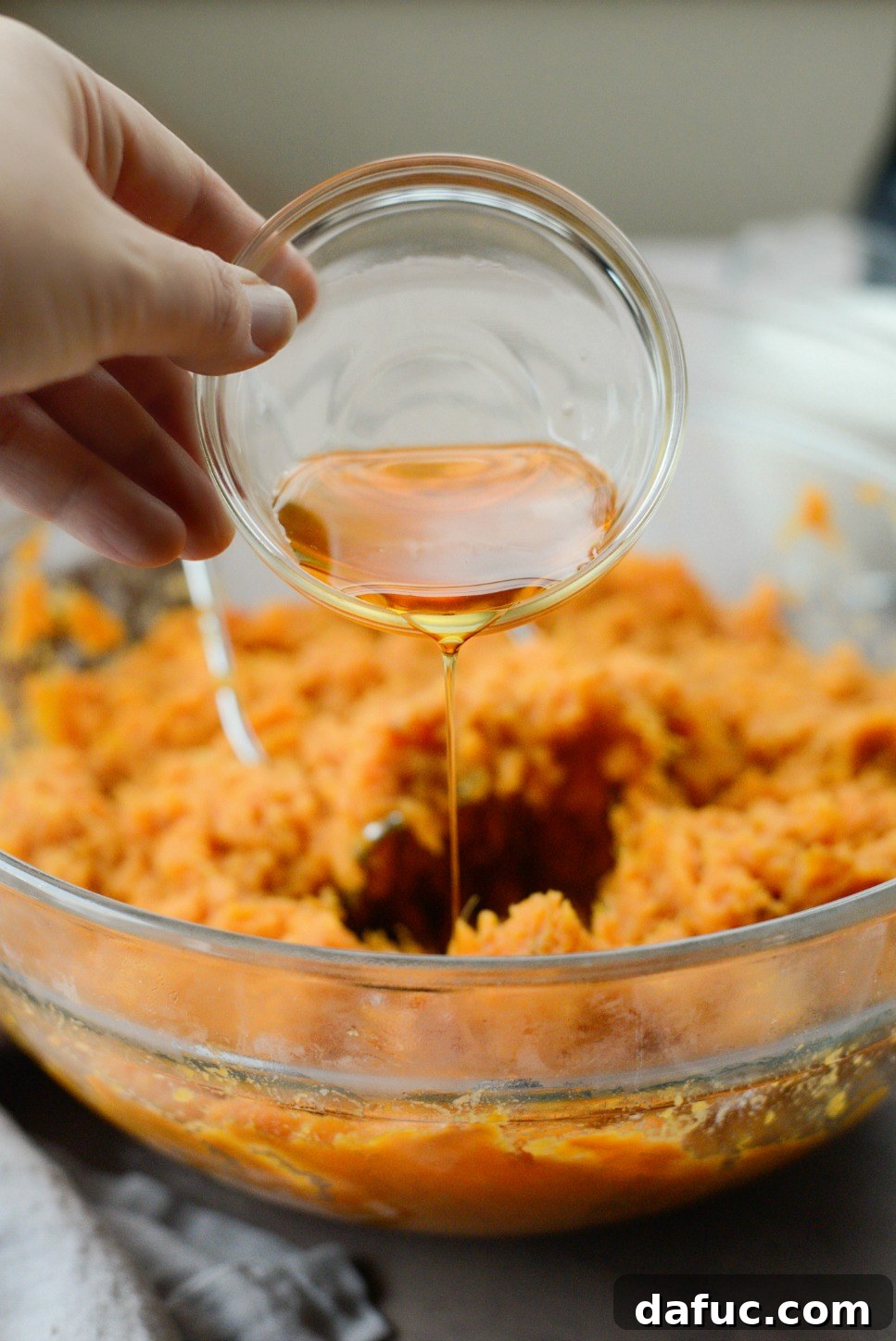 Silky Maple Sweet Potato Mash 9 Pouring maple syrup into the sweet potato mash