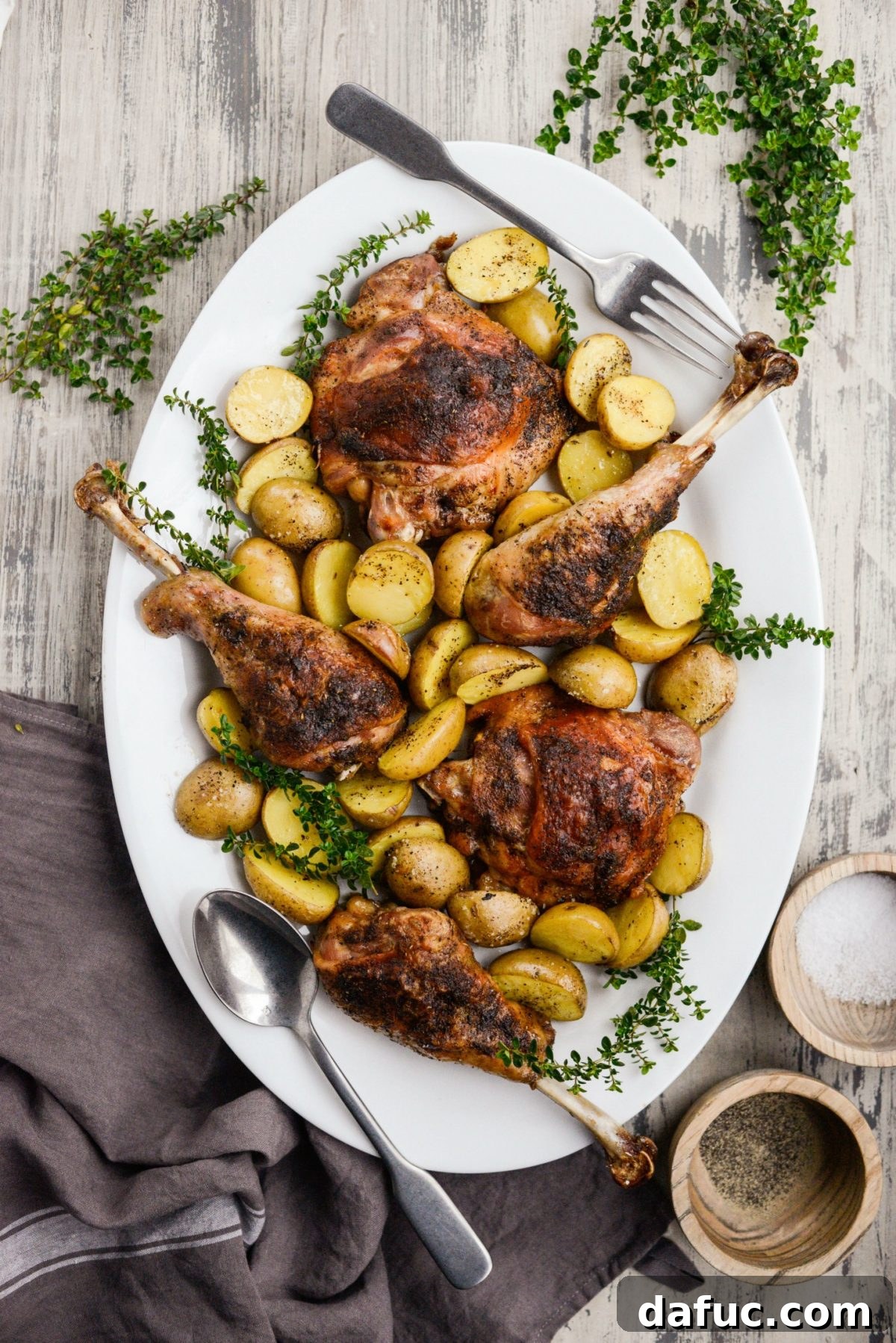Family-style serving platter with beautifully arranged Roasted Turkey Thighs and Drumsticks and roasted potatoes