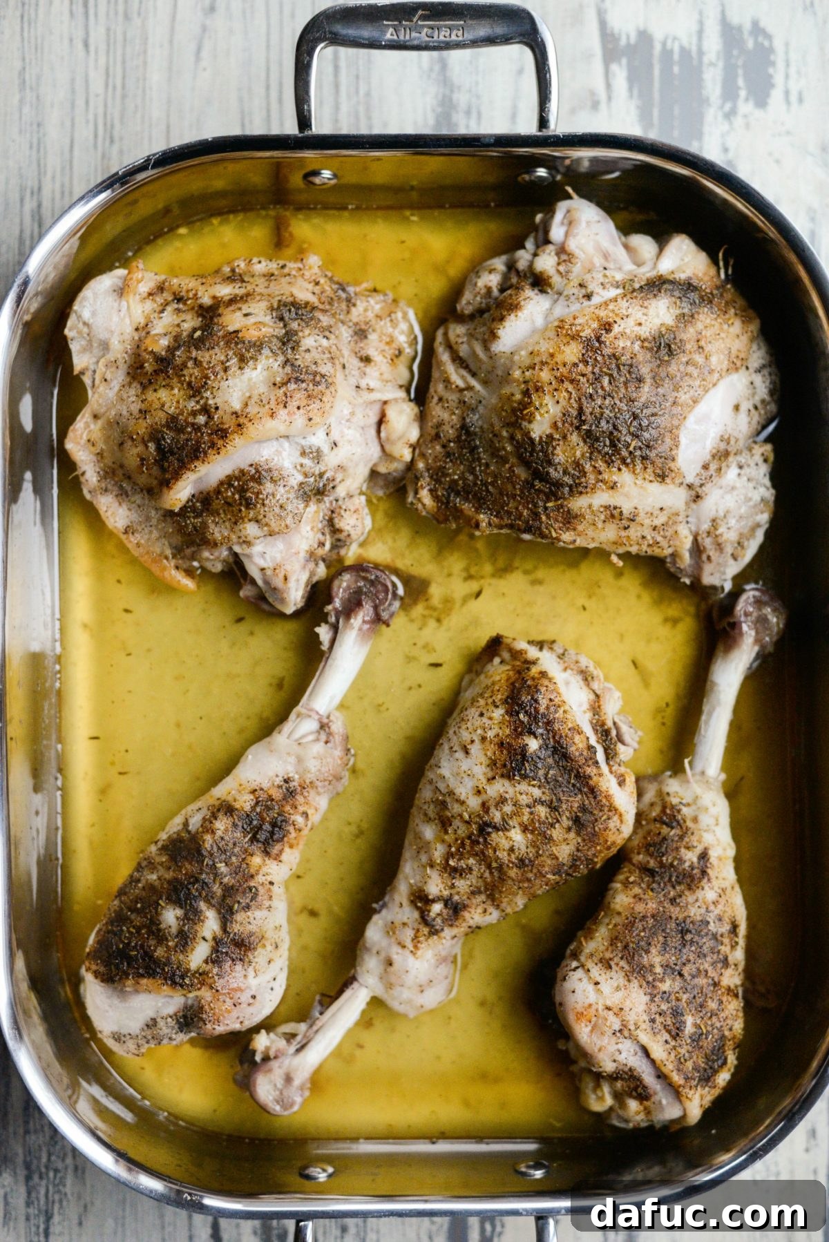 Partially roasted turkey thighs and drumsticks, glistening with juices before basting
