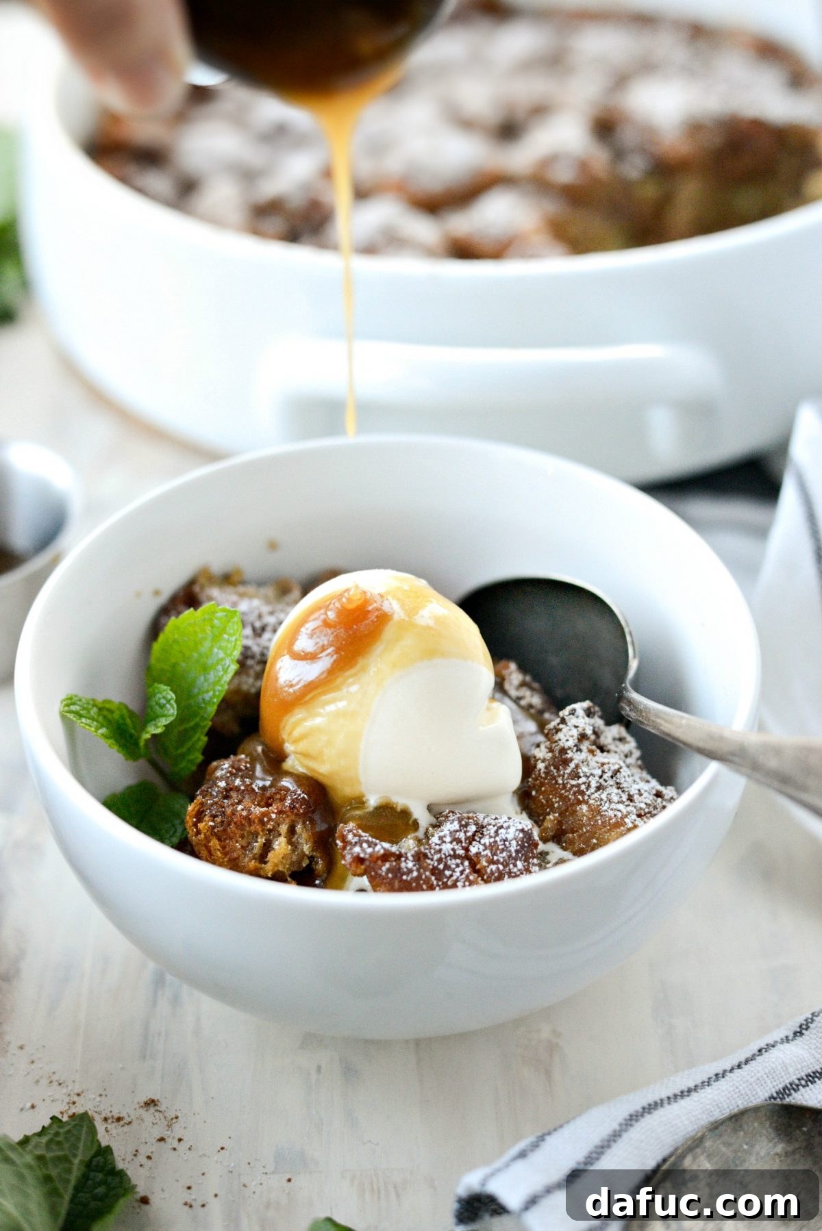 Autumn Spiced Doughnut Bread Pudding 25 Close-up of Cider Mill Doughnut Bread Pudding with abundant butter rum sauce drizzled over ice cream