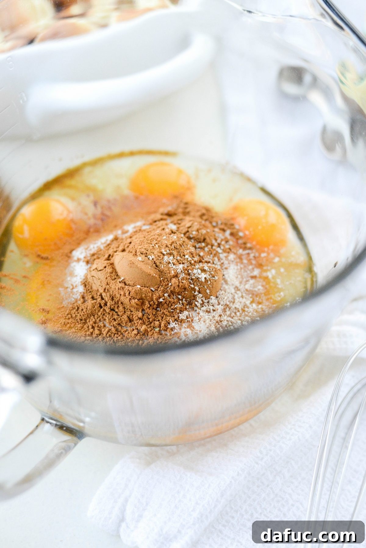 Autumn Spiced Doughnut Bread Pudding 8 Adding granulated sugar, vanilla extract, ground cinnamon, and freshly grated nutmeg to eggs in a bowl