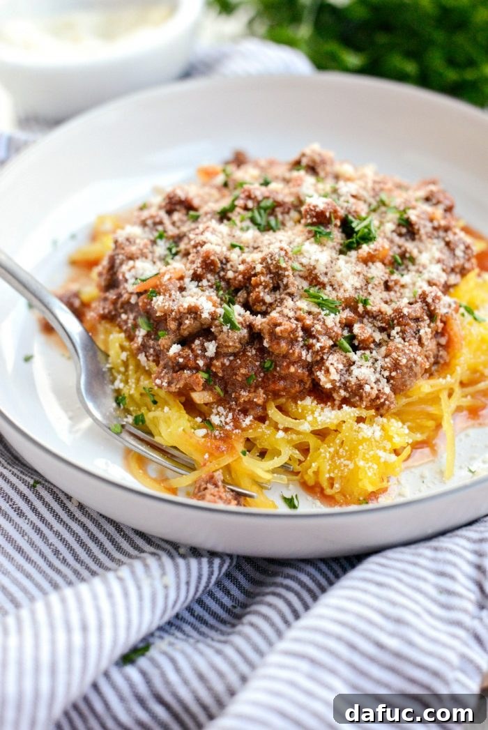 Roasted spaghetti squash alongside a bowl of rich meat sauce