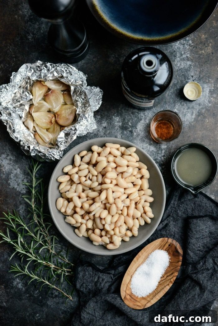 Key ingredients for making the best Roasted Garlic and Rosemary White Bean Dip: fresh garlic, cannellini beans, and aromatic rosemary.