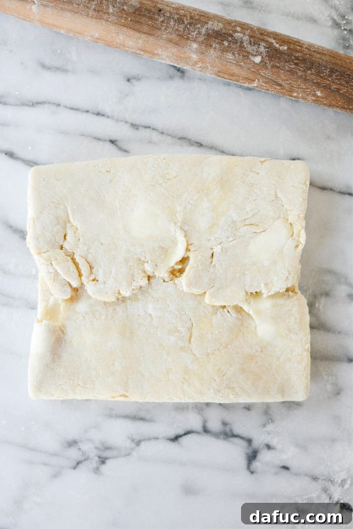 Effortless Homemade Croissant Perfection 15 Folding the new shorter sides of the dough into the middle