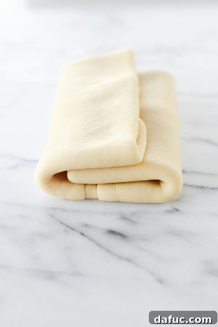 Effortless Homemade Croissant Perfection 17 Wrapping the dough tightly in plastic wrap for refrigeration