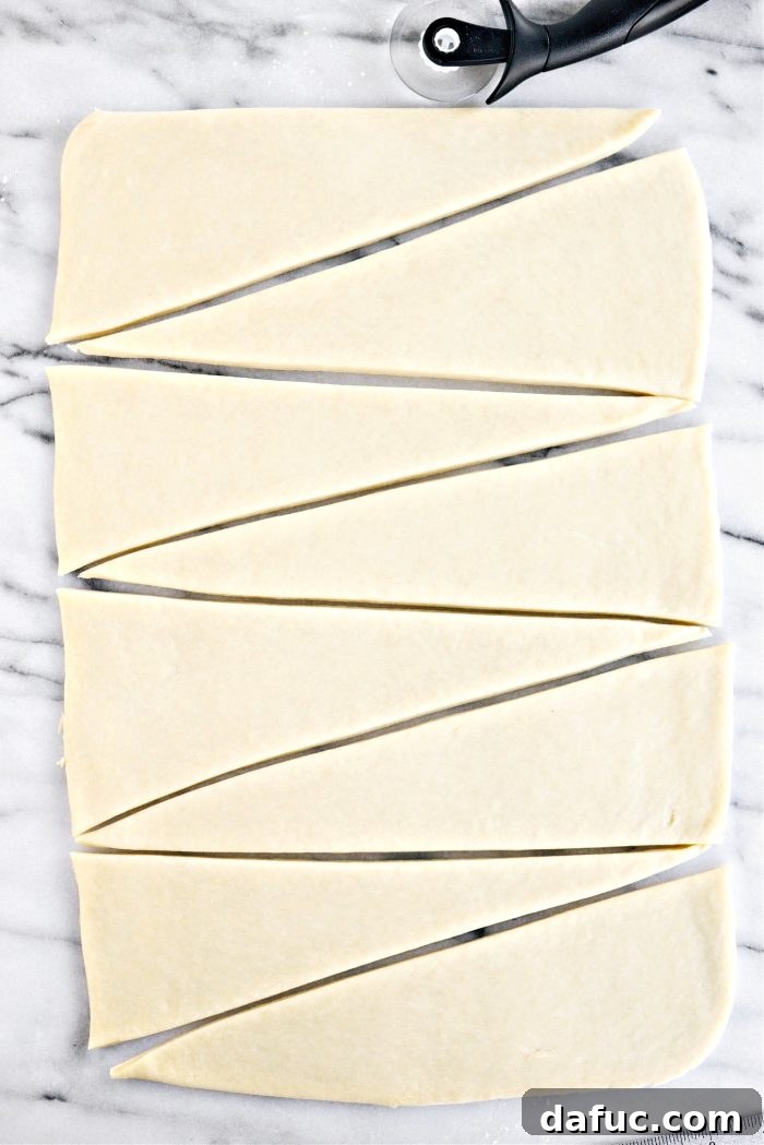 Effortless Homemade Croissant Perfection 20 Cutting the dough into triangles for croissants