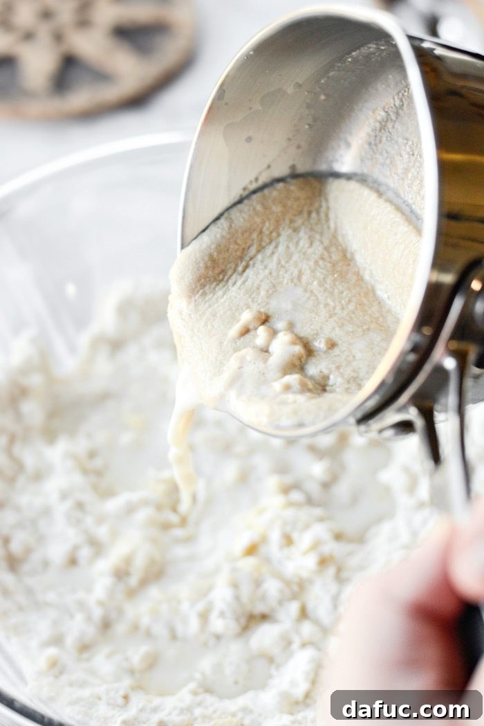 Effortless Homemade Croissant Perfection 9 Pouring the cooled yeast mixture into the dry ingredients