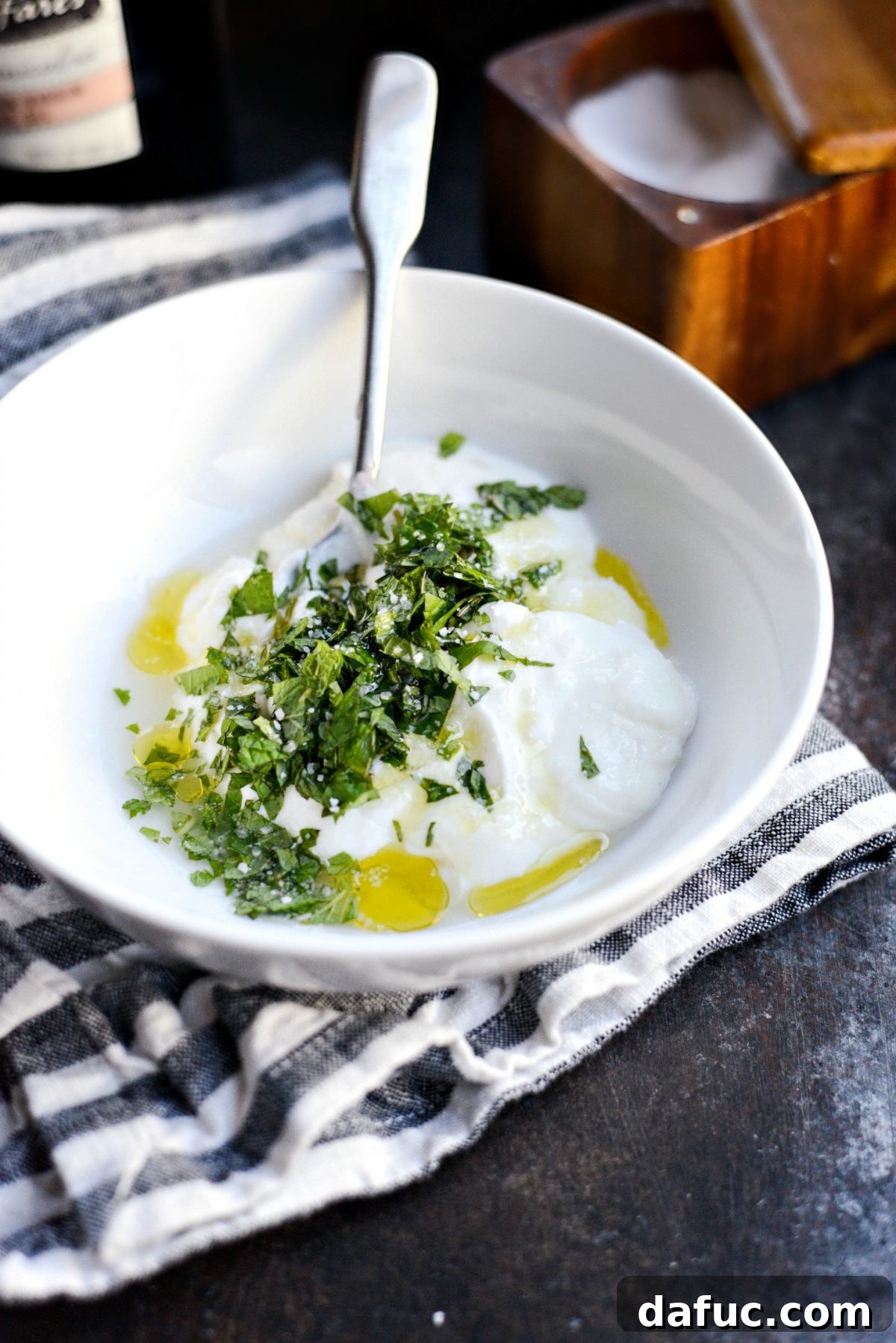 Ingredients for the mint yogurt sauce laid out: yogurt, fresh mint, lemon, olive oil.