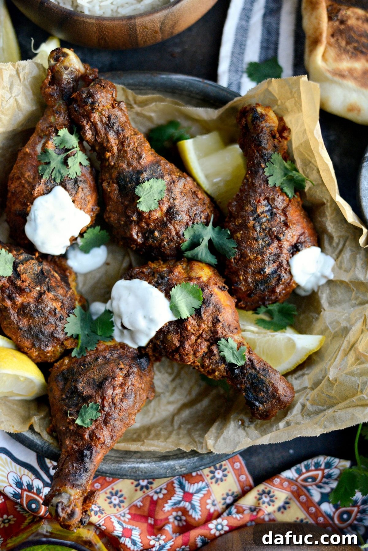 Oven Tandoori Chicken with vibrant mint yogurt sauce and fresh garnishes.