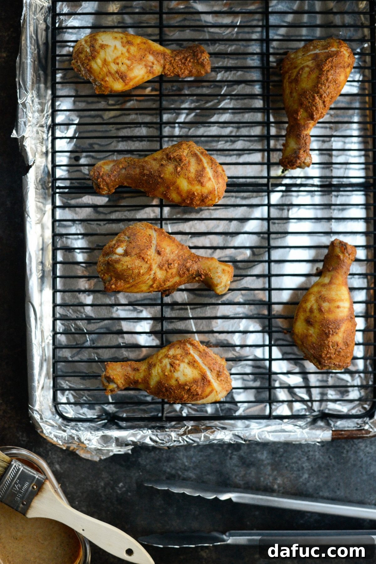 Partially baked chicken legs before the first brushing with reserved marinade.