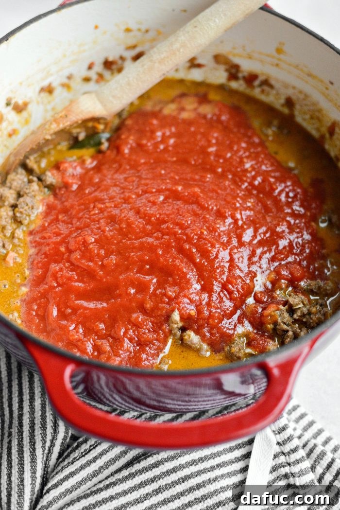 Stirring in San Marzano crushed tomatoes to the bolognese