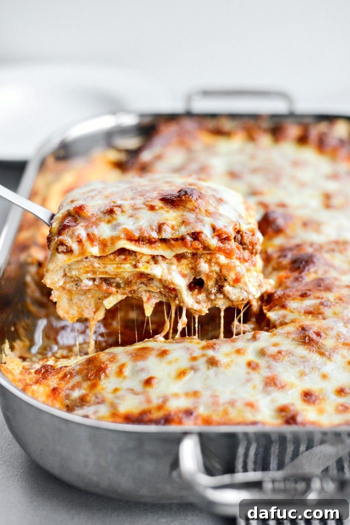 Cutting and serving a slice of Homemade Three-Meat Bolognese Lasagna