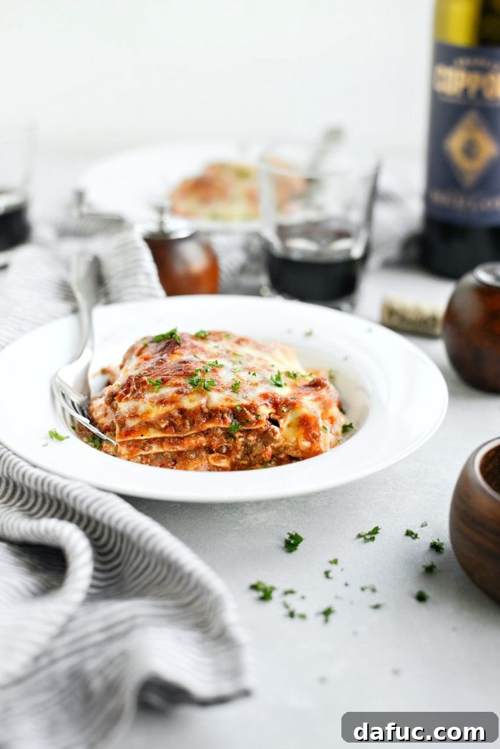 Close-up of a slice of Homemade Three-Meat Bolognese Lasagna with creamy layers