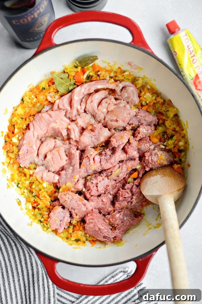 Adding ground beef, pork, and veal to the Dutch oven