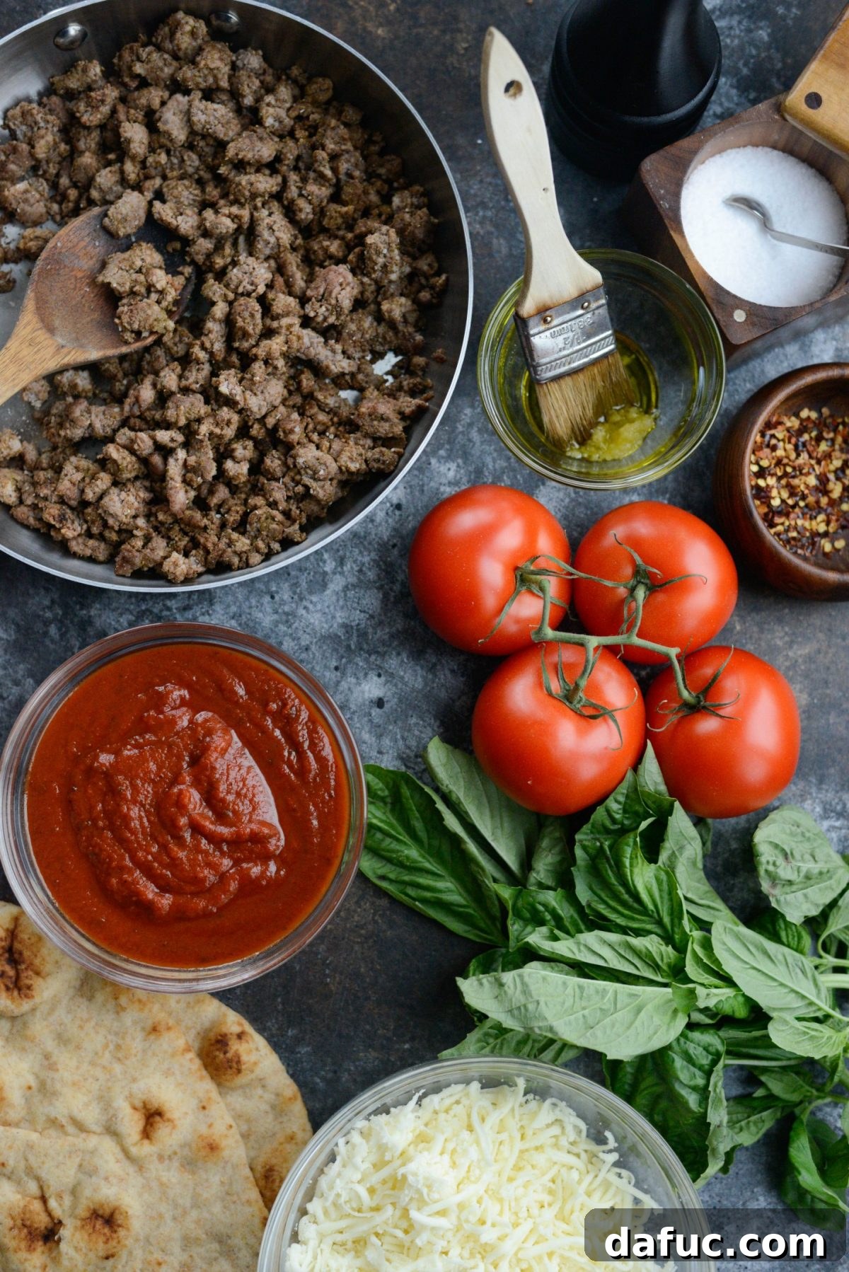 Levantine Lamb Margherita Pizza 5 A collection of fresh ingredients laid out, including whole wheat naan, tomatoes, mozzarella, lamb, and spices, for the Lebanese Margherita Lamb Pizza.