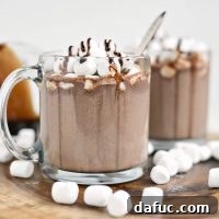 Mocha Magic 18 Espresso Hot Chocolate in a mug with whipped cream and chocolate syrup