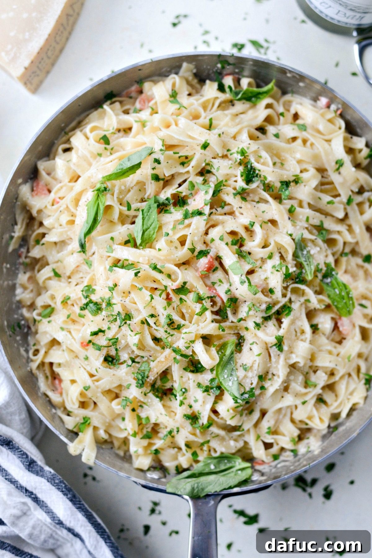 Fresh basil and parsley being added to the tossed Christmas Fettuccine.