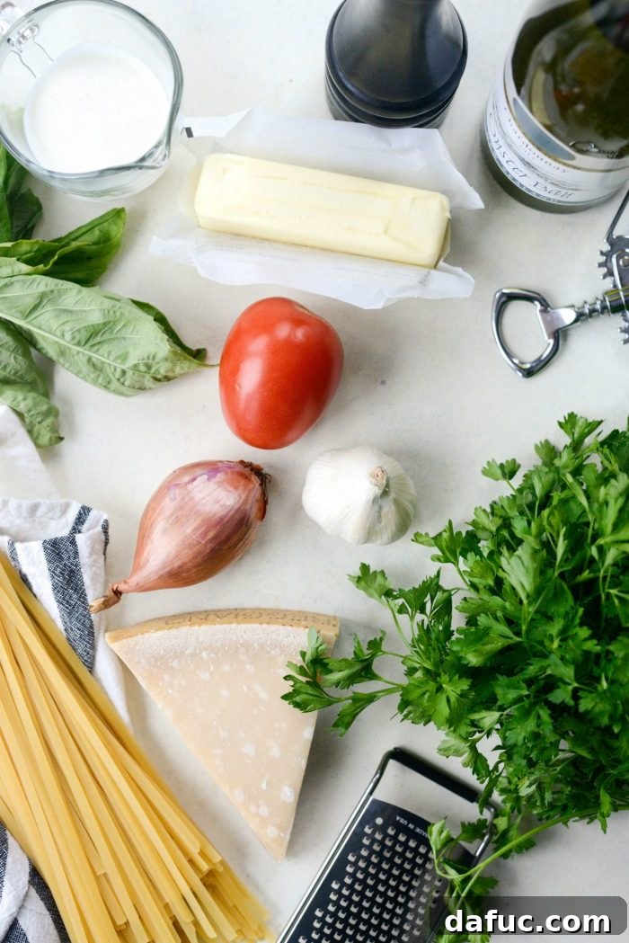 Ingredients for Christmas Fettuccine laid out: fettuccine, shallots, garlic, tomatoes, wine, butter, cream, Parmesan, basil, parsley.