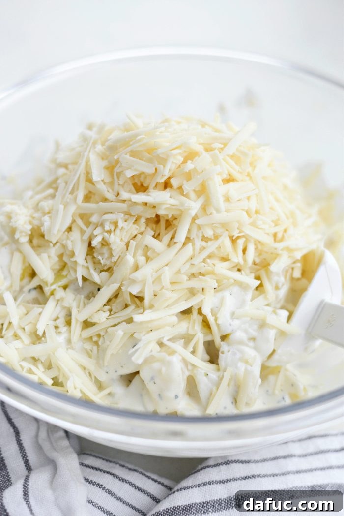 Gruyere Potato Gratin 16 Adding shredded Gruyere cheese to the potatoes and sauce.