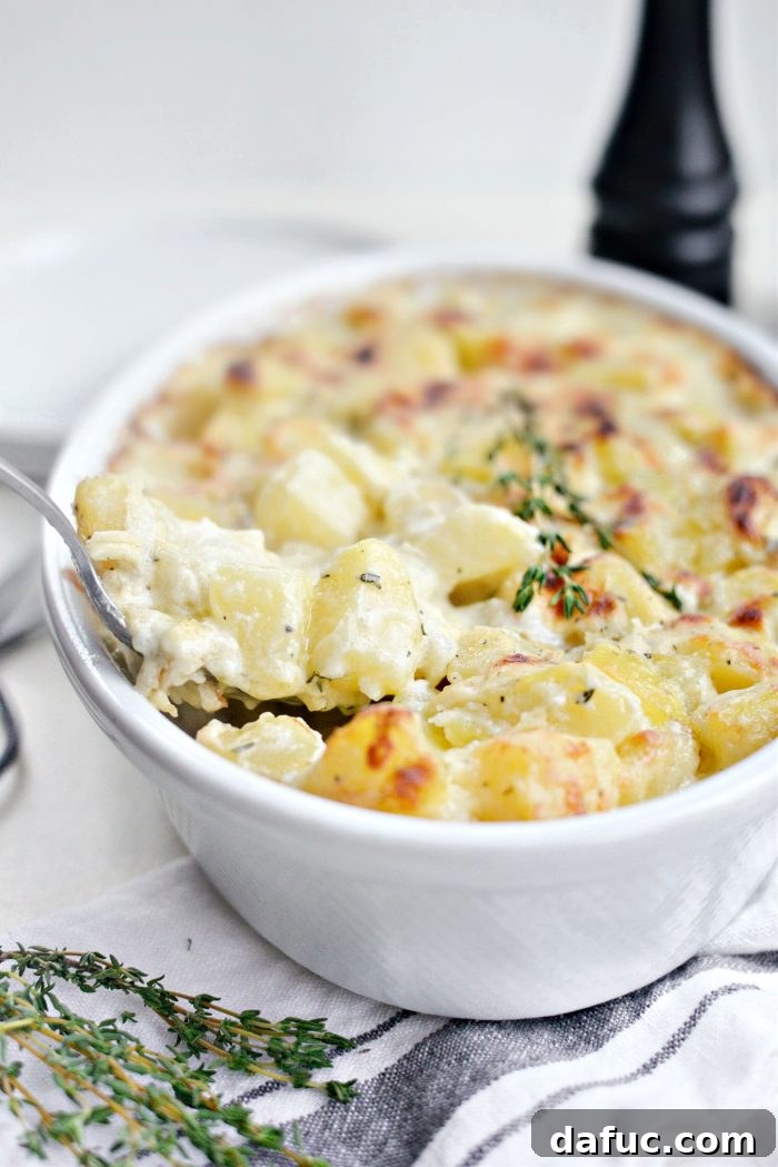Gruyere Potato Gratin 3 Serving spoonfuls of Cheesy Gruyere Potatoes from a baking dish.