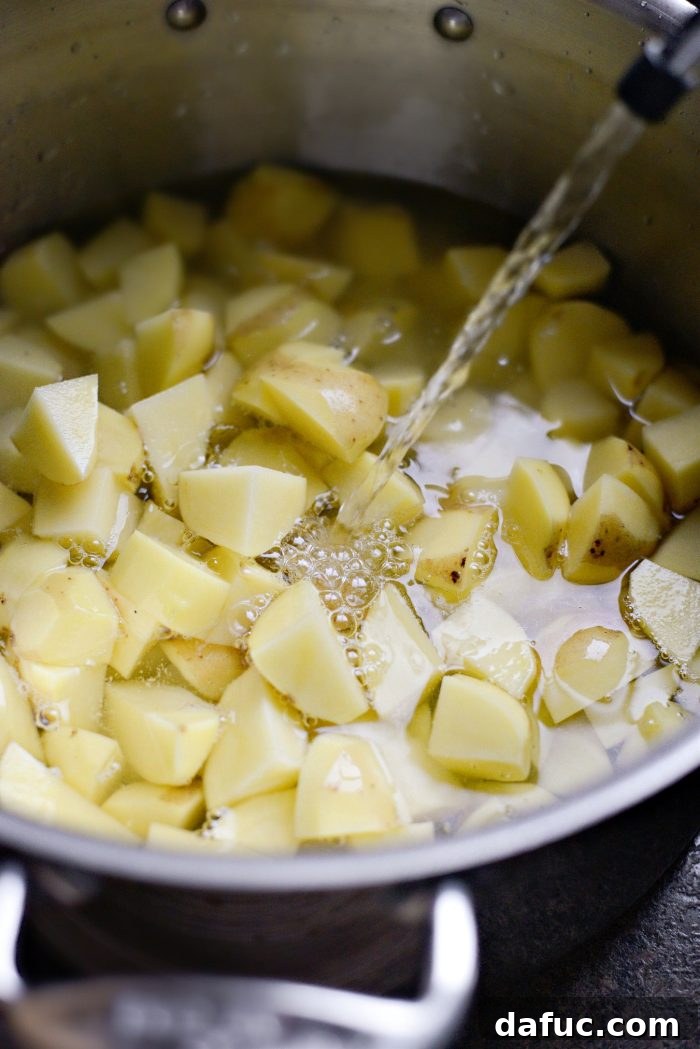 Gruyere Potato Gratin 5 Cubed Yukon gold potatoes being added to a pot of cold water.