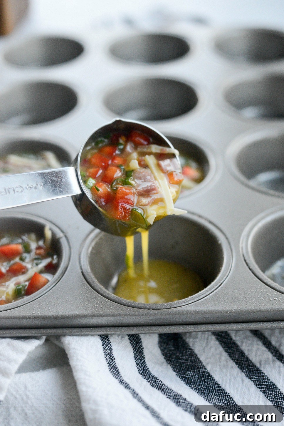 Dividing the egg mixture into a prepared muffin tin