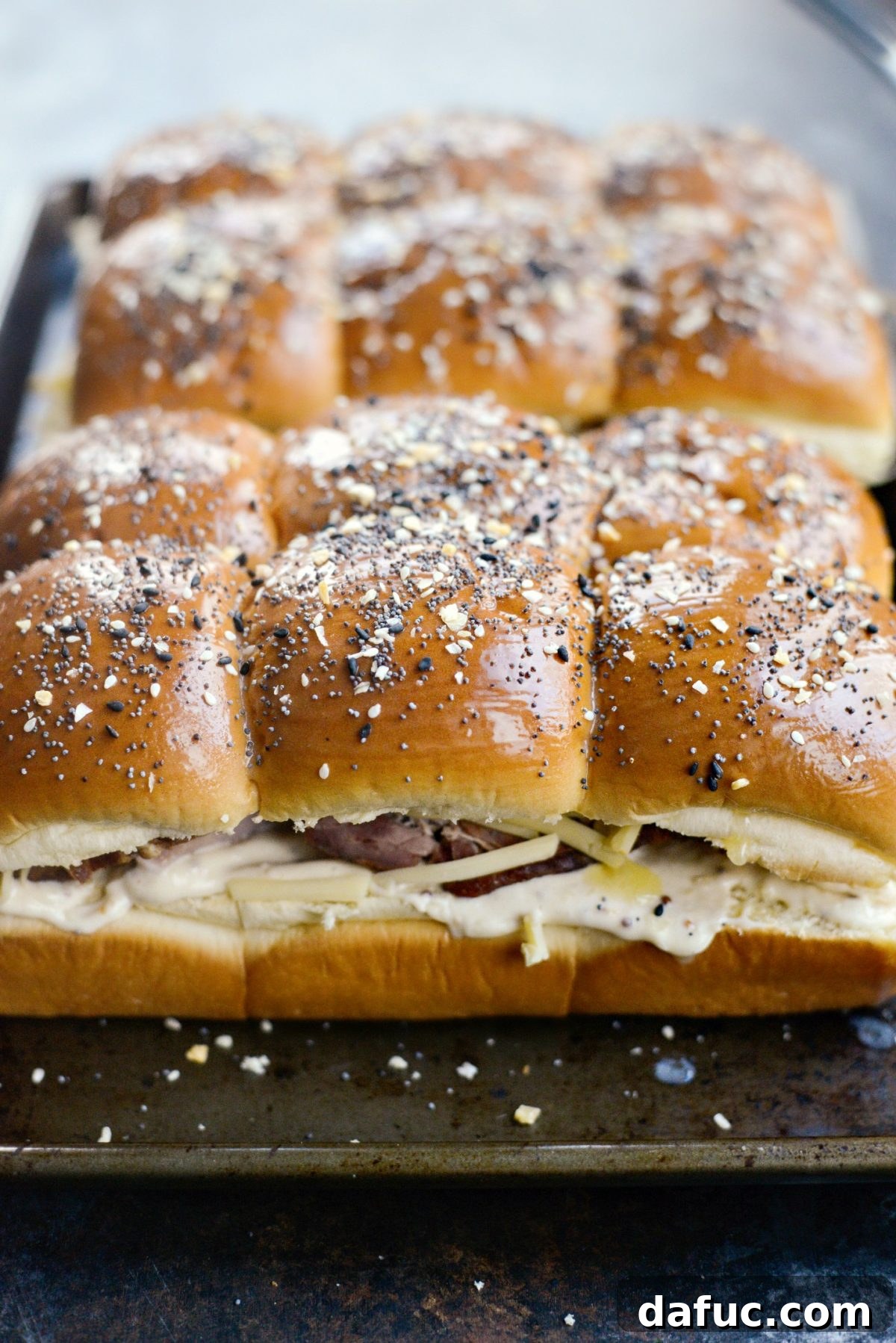 Gourmet Ham and Gouda Bites with Zesty Roasted Garlic Dijon 11 Sprinkling everything seasoning over the buttered rolls