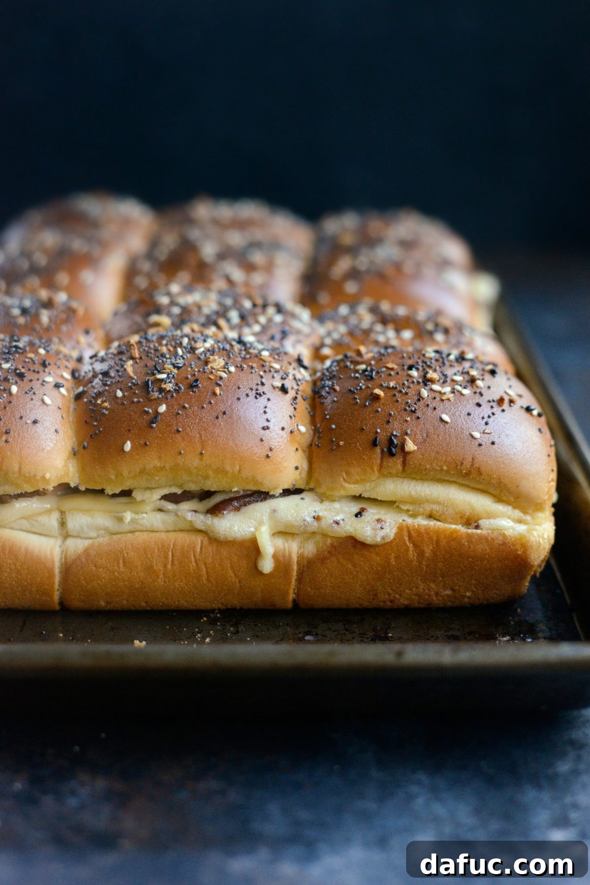 Gourmet Ham and Gouda Bites with Zesty Roasted Garlic Dijon 12 Freshly baked Ham and Gouda Party Sandwiches, golden and bubbly