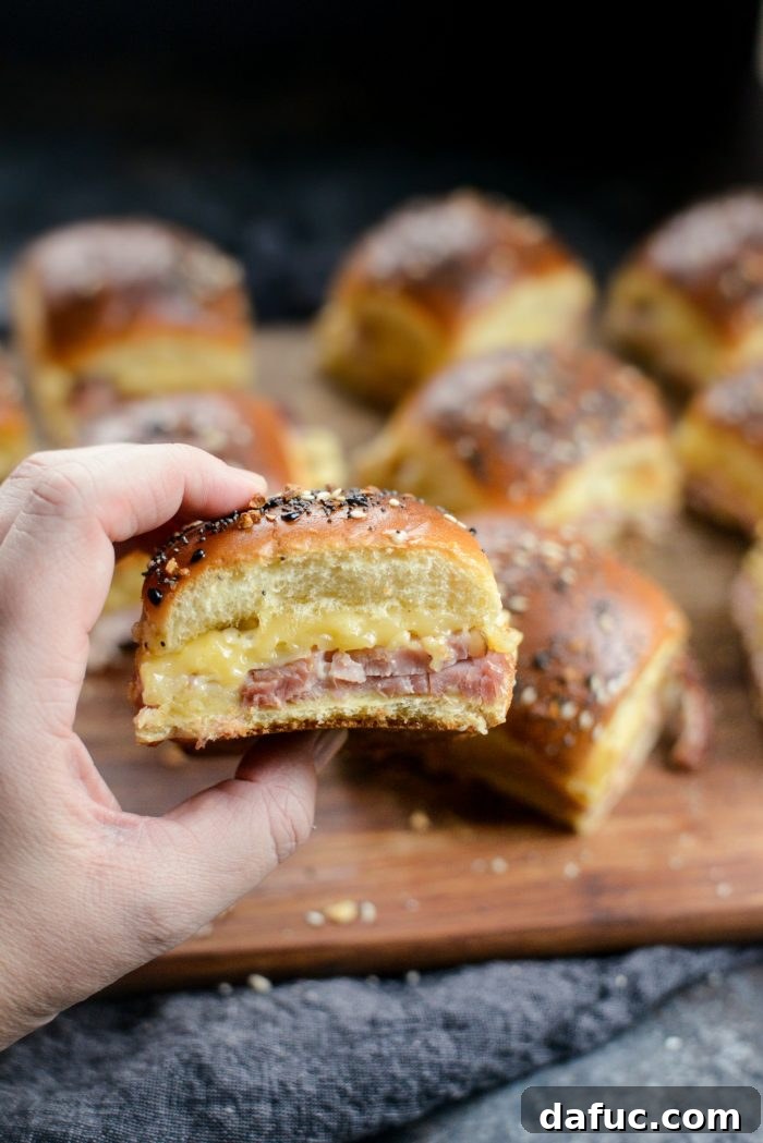 Gourmet Ham and Gouda Bites with Zesty Roasted Garlic Dijon 14 Ham and Gouda Party Sandwiches on a wooden board