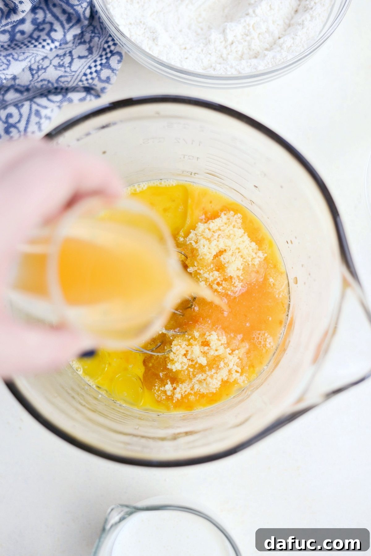 Golden Clementine Bliss Cake 12 Wet ingredients including zesty sugar, clementine juice, and oil in a bowl