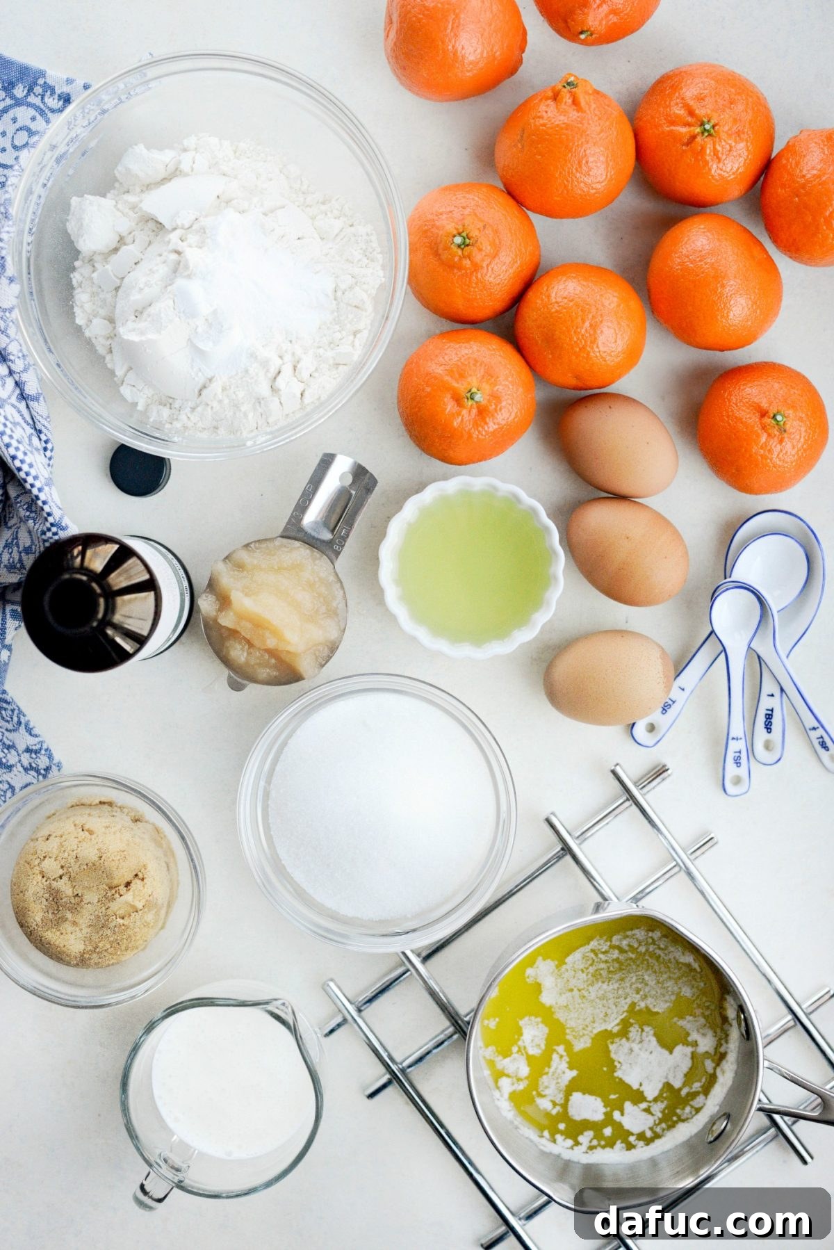 Golden Clementine Bliss Cake 4 Key ingredients for Clementine Cake laid out, including fresh clementines, butter, and sugar