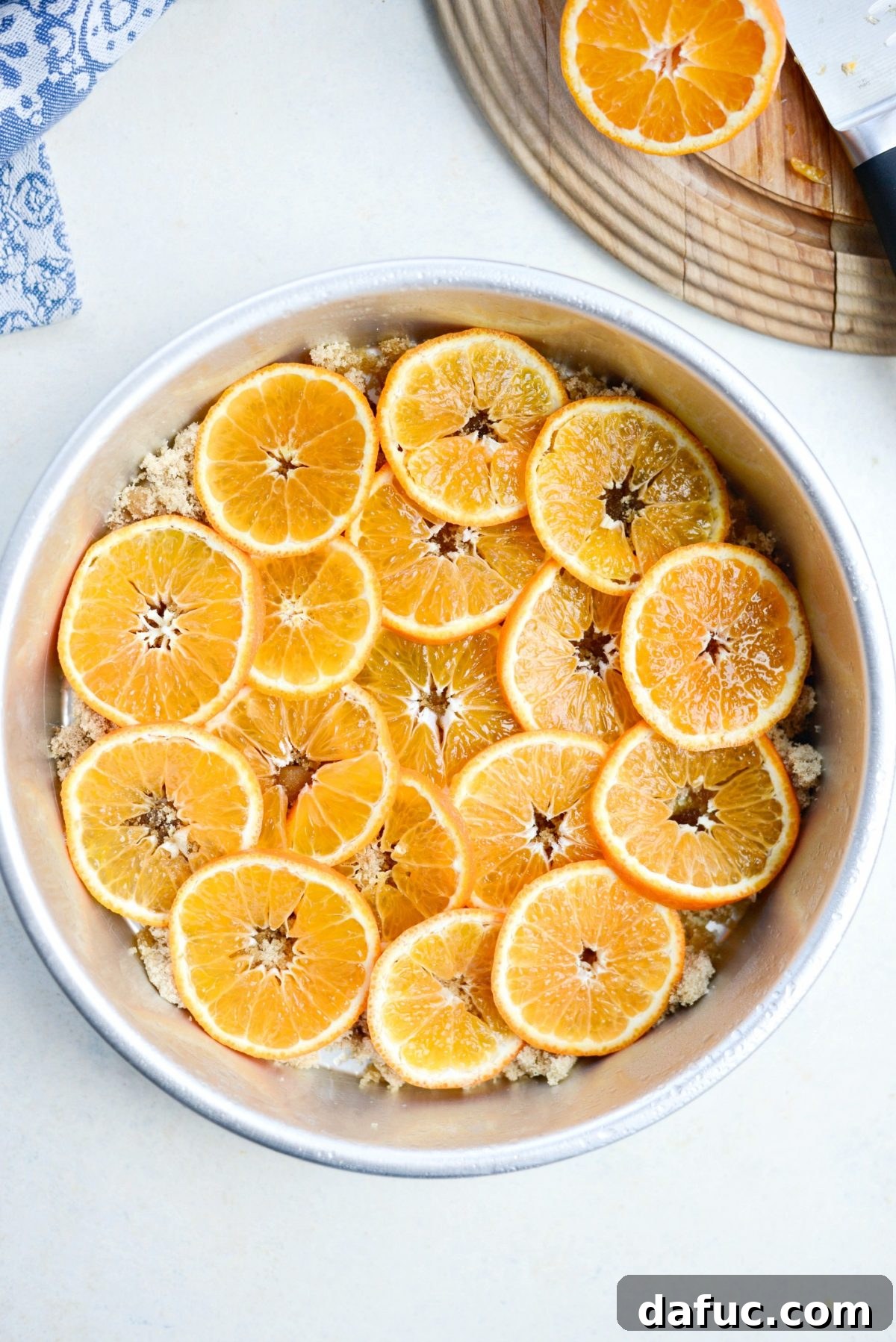 Golden Clementine Bliss Cake 7 Arranged clementine slices on top of butter and brown sugar in a cake pan