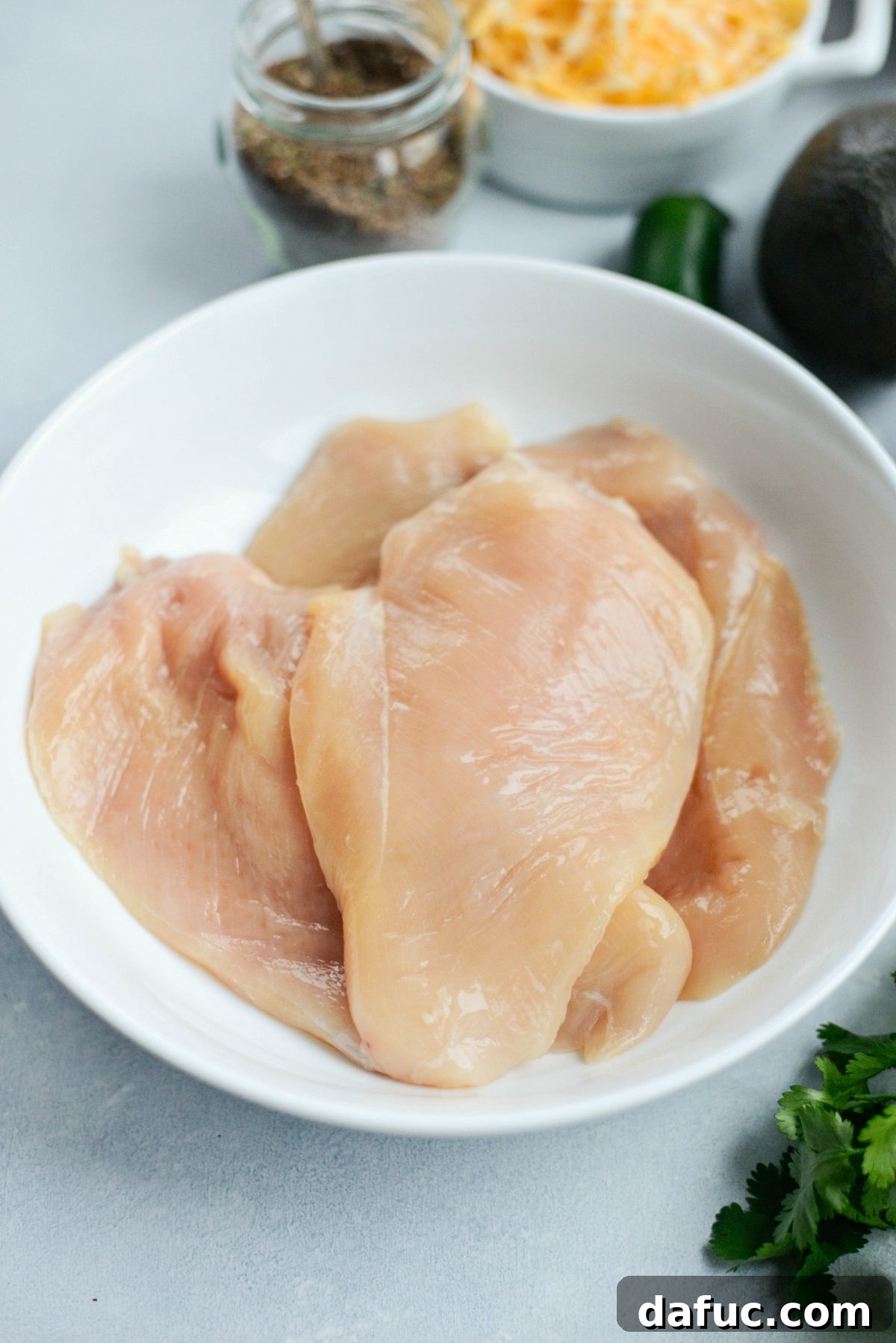 Raw boneless, skinless chicken breasts in a shallow dish, ready for seasoning.
