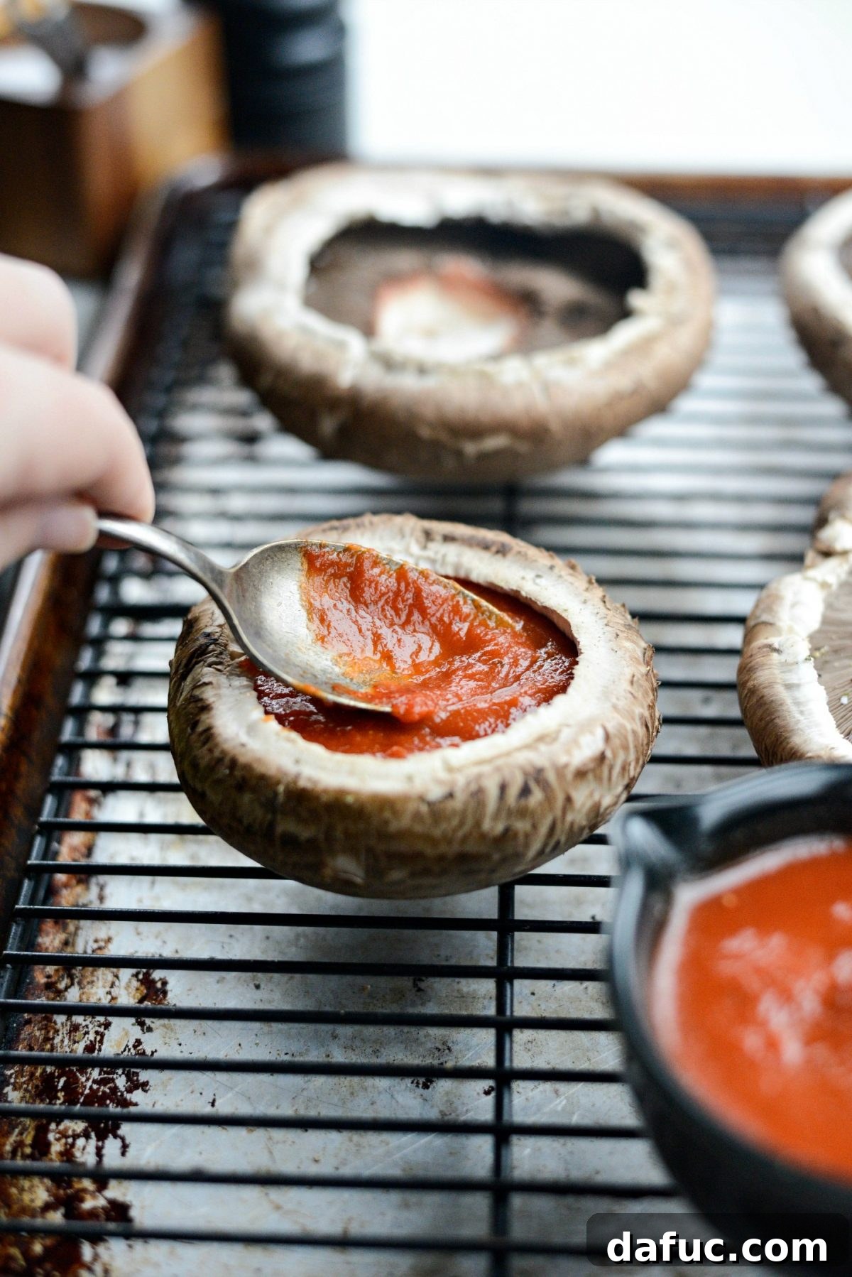 Caprese Stuffed Roasted Portobello Caps 8 Spreading marinara sauce inside the portobello mushroom caps